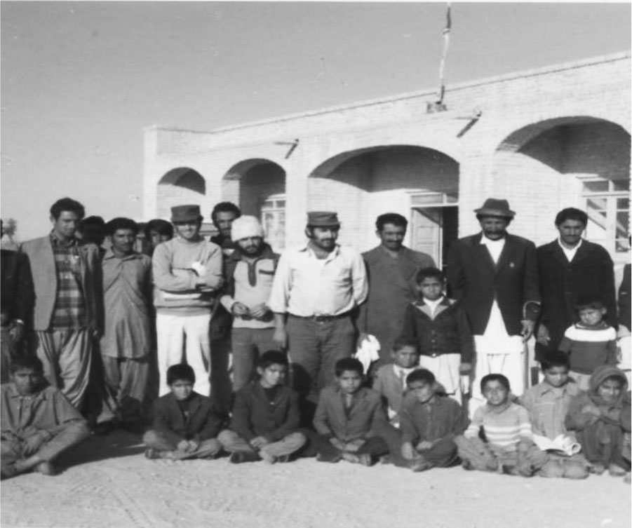 با دکتر و عده ای از اهالی گلمورتی در کنار ساختمان دبستان
